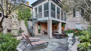 Une maison moderne dotée d’un patio aménagé avec du mobilier d’extérieur et un chemin en pierre.
