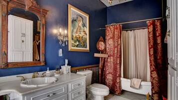 A bathroom with a double sink, a toilet, and a bathtub.