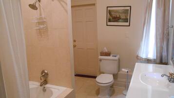 A bathroom with a bathtub, toilet, and sink.
