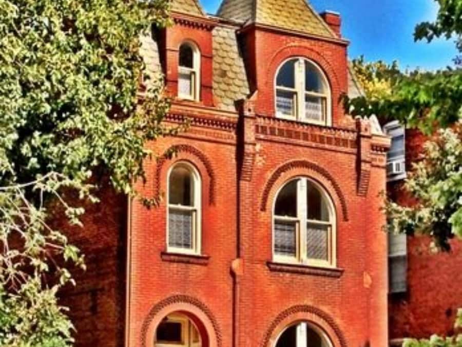 A red brick building with a gabled roof and arched windows.