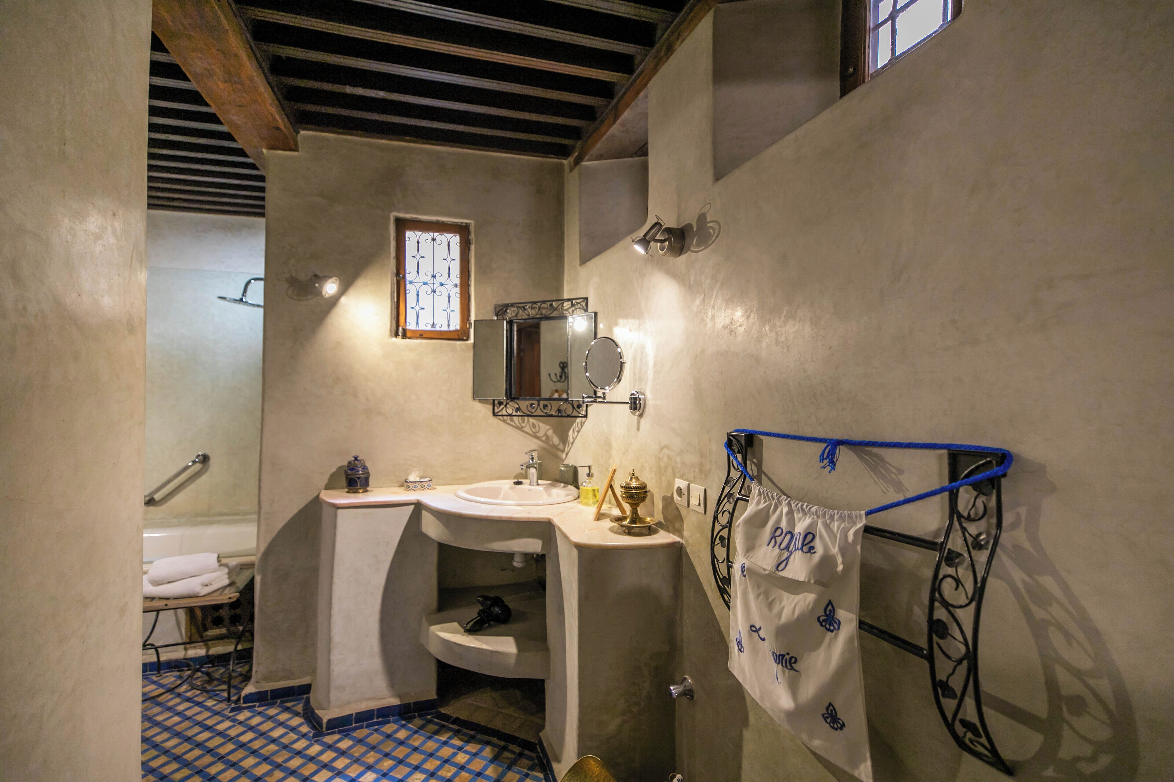 A bathroom with a sink, mirror, and towel rack.