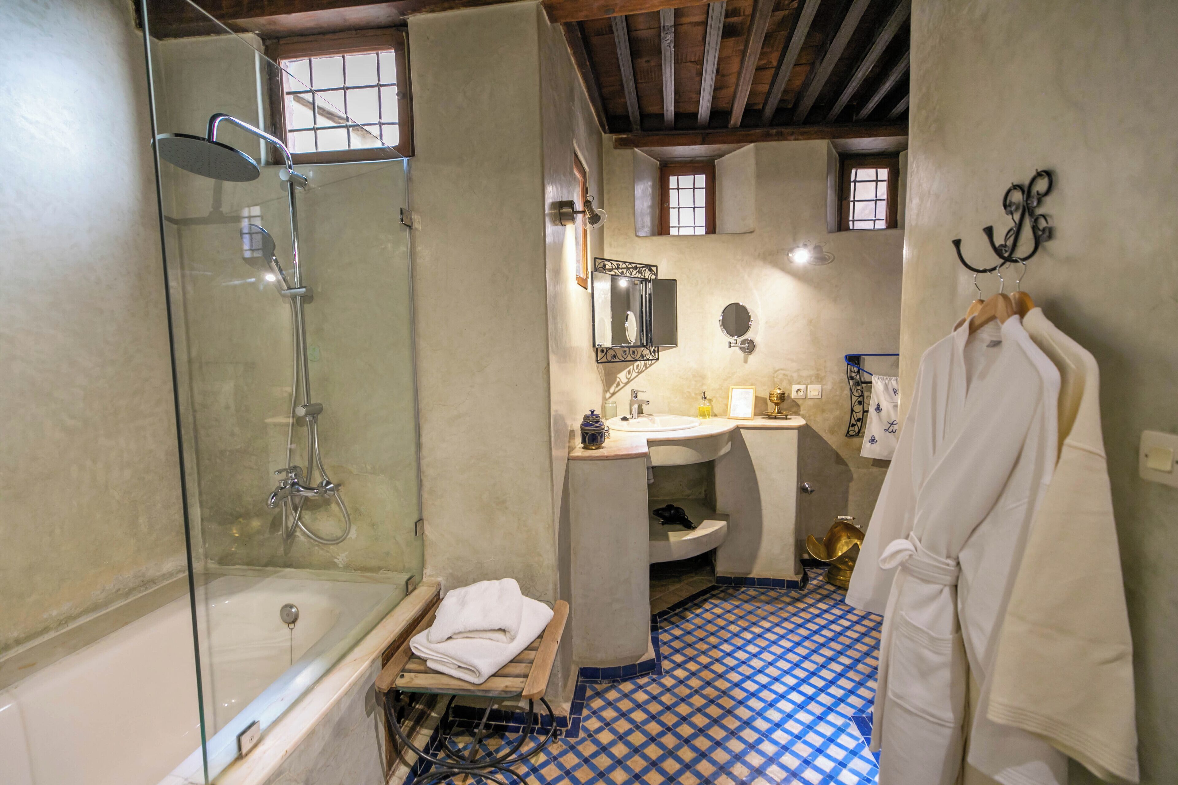 A bathroom with a glass-enclosed shower, a bathtub, a sink, and a mirror.