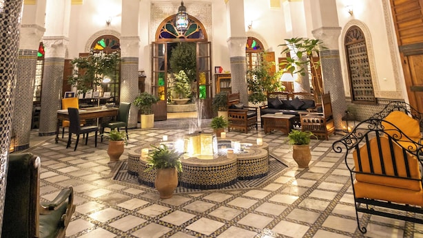 A spacious lobby with a high ceiling, ornate columns, and a central fountain.