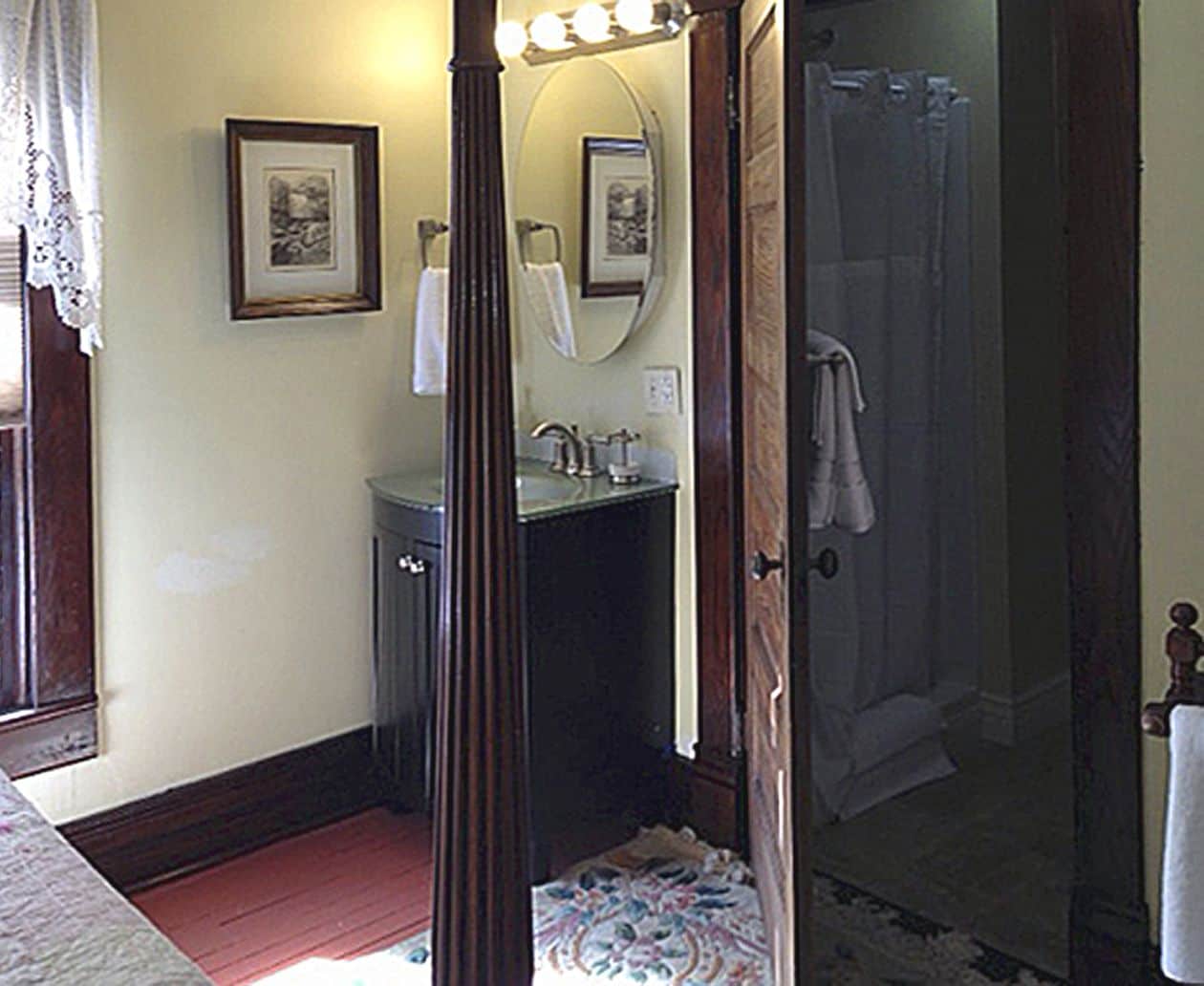 A bathroom with a vanity, sink, mirror, and shower.