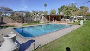 A rectangular swimming pool with a tiled deck, a covered patio area, and a brick wall. - PX001 3 Bedroom Apartment By Senstay (Phoenix)