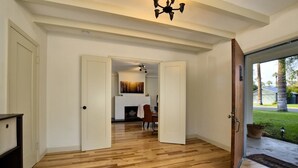 A spacious hallway with wooden flooring leading to a room with a fireplace and a dining area. - PX002 4 Bedroom Apartment By Senstay (Phoenix)