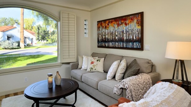 A living room with a large window, a sofa, a coffee table, and a painting on the wall. - PX002 4 Bedroom Apartment By Senstay (Phoenix)