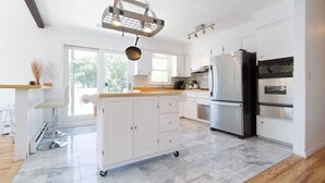 A modern kitchen with white cabinets, a stainless steel refrigerator, and a marble floor. - SH001 5 Bedroom Holiday home By Senstay (Sagaponack)