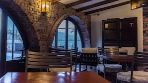 Un restaurante con paredes de ladrillo, ventanas arqueadas y muebles de madera.
