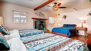 A bedroom with two beds, a ceiling fan, a fireplace, and a nightstand with a lamp. - PX008 4 Bedroom Apartment By Senstay (Scottsdale)