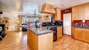 A kitchen with a central island, wooden cabinets, a microwave, and a stove. - PX008 4 Bedroom Apartment By Senstay (Scottsdale)