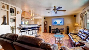 A living room with a bar area, leather sofas, a television, and a ceiling fan. - PX008 4 Bedroom Apartment By Senstay (Scottsdale)