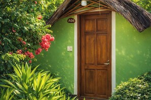A wooden door with a green wall, a number plaque, and a thatched roof. - FORTUNE HOTEL 2 LUCKY STAY Phu Quoc (Phu Quoc)