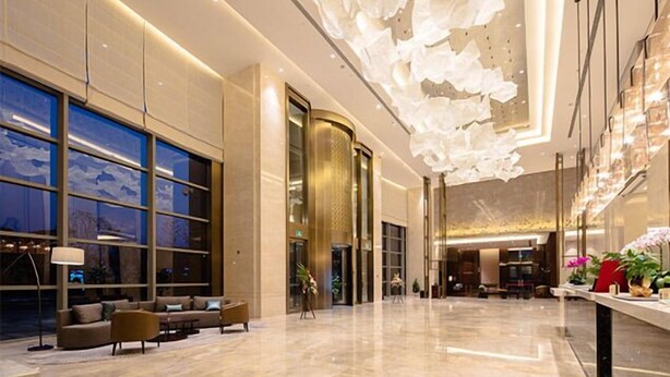 A spacious lobby with a modern design, featuring a large seating area, a reception desk, and a decorative ceiling. - Golden Eagle Summit Hotel Nanjing China (Nanjing)