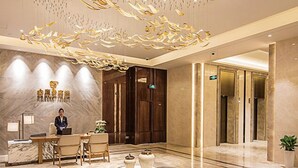 A hotel lobby with a reception desk, seating area, and elevators. - Golden Eagle Summit Hotel Nanjing China (Nanjing)