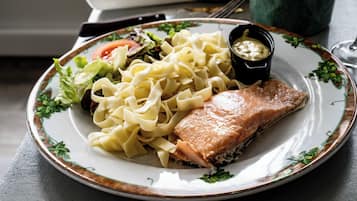 Ein Teller mit Lachs, Nudeln und Salat.