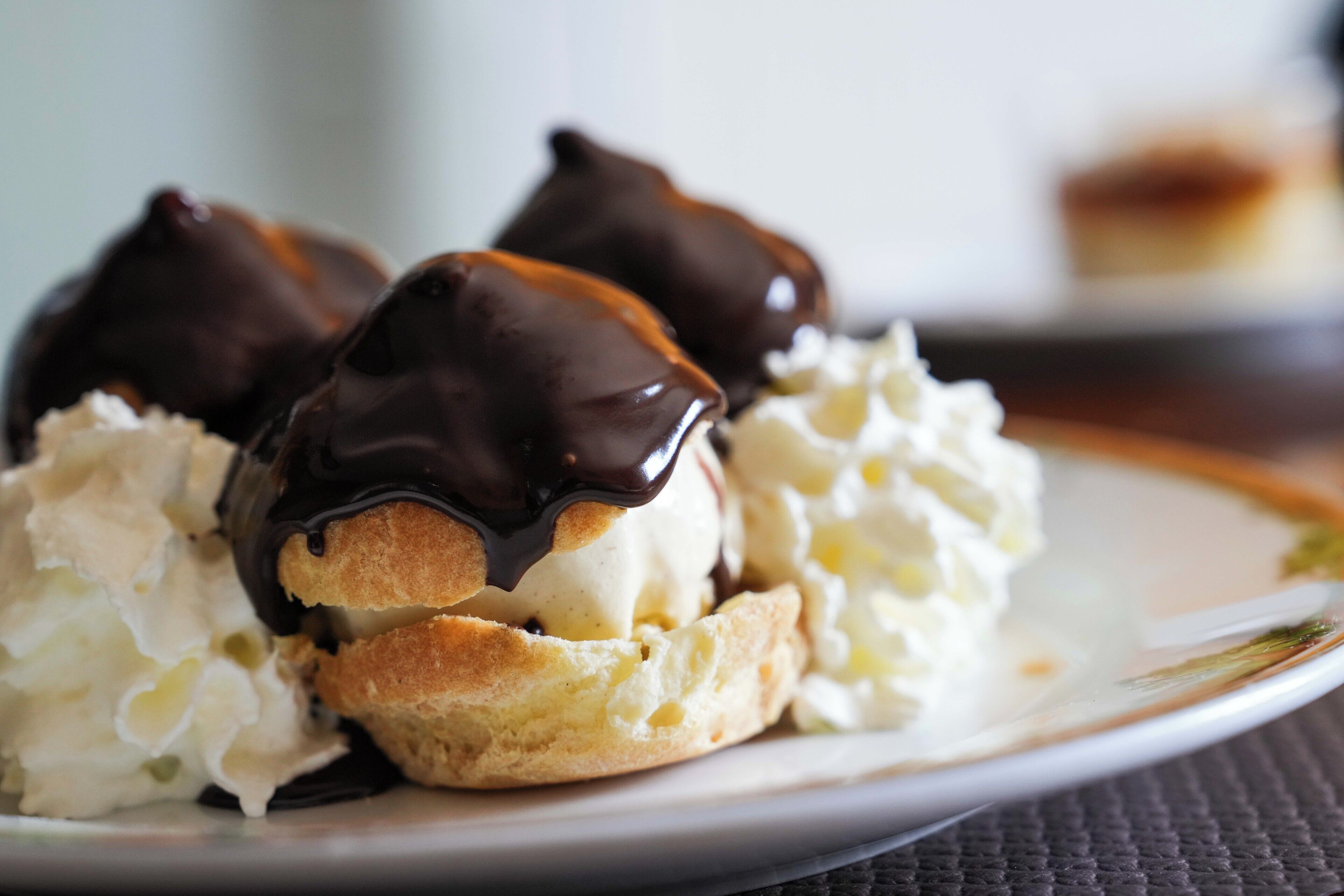 Un plato con eclair y crema batida.