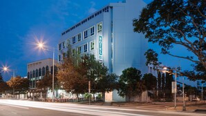 A hotel with a modern design, featuring a prominent 'HOTEL' sign on the facade.