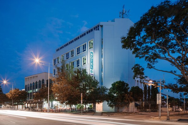 Een hotel met een modern design, met een opvallend 'HOTEL' bord op de gevel.
