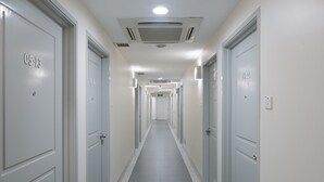 A long, narrow hallway with doors labeled 05-13 and 15-12, leading to rooms.
