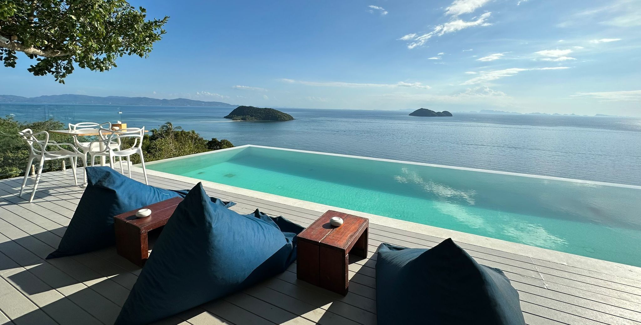 A poolside area with a view of the sea and distant islands.
