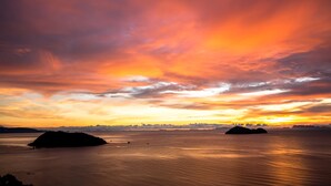 A sunset over a calm body of water with two islands in the distance. - Bluerama Resort (Ko Pha-ngan)