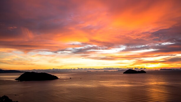A sunset over a calm body of water with two islands in the distance. - Bluerama Resort (Ko Pha-ngan)