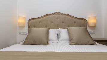 A neatly made bed with a tufted headboard, two beige pillows, and a white duvet.