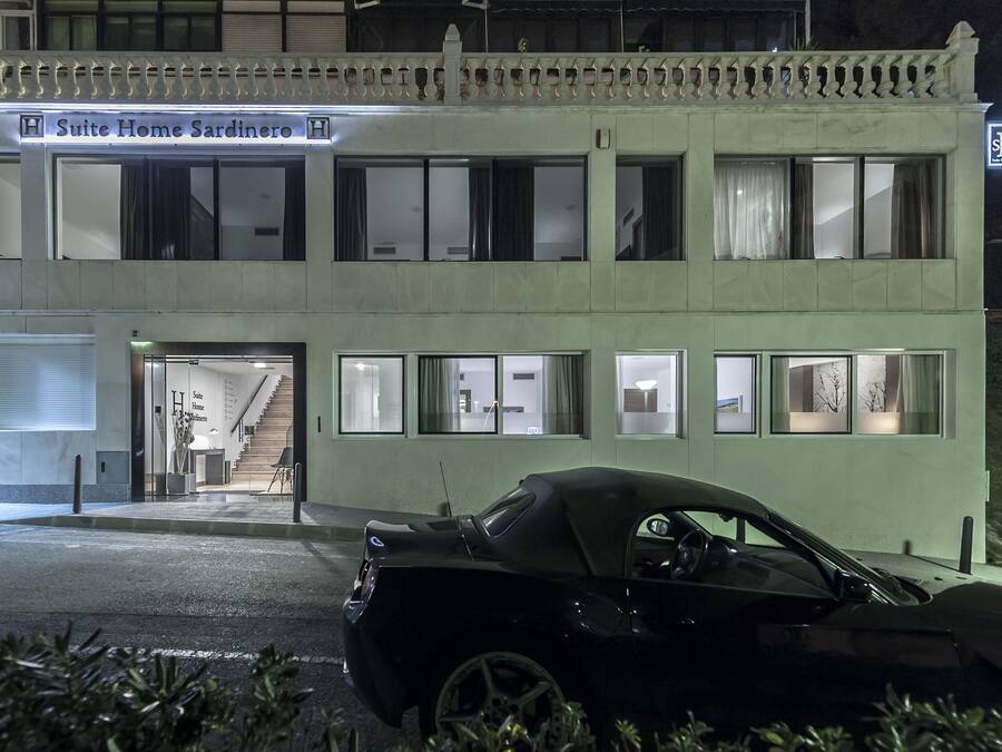 Un hotel llamado 'Suite Home Sardinero' con una fachada moderna, múltiples ventanas y una escalera que conduce a la entrada.