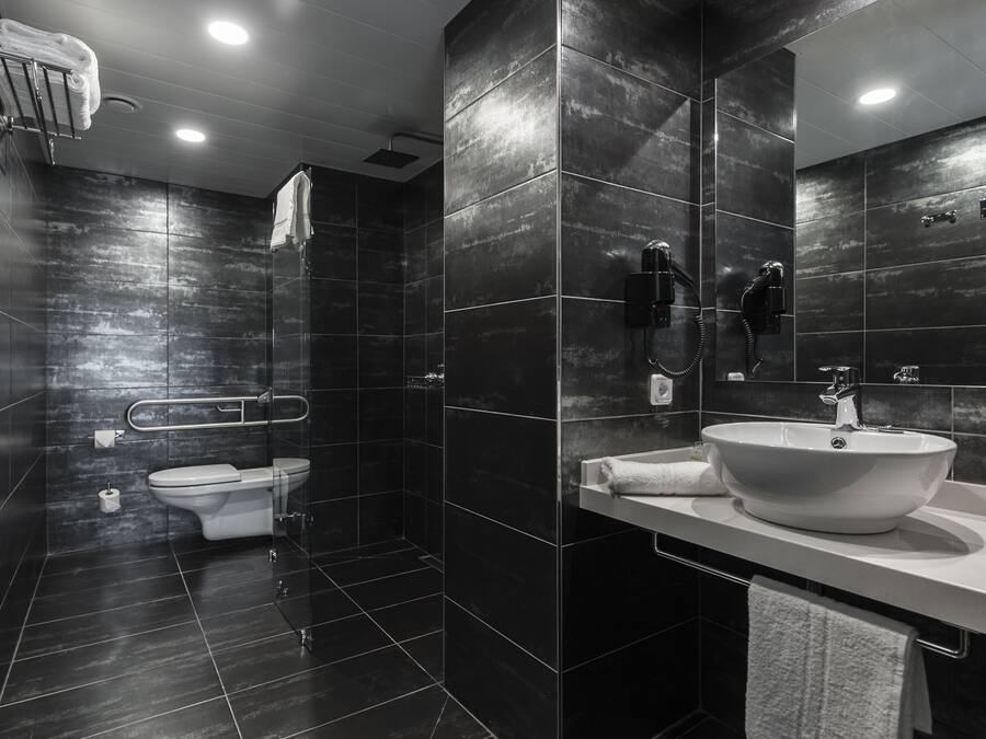 Een moderne badkamer met een ruime wastafel, toilet en douche.