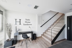 Un interior moderno con una escalera, un escritorio y un cartel en la pared.