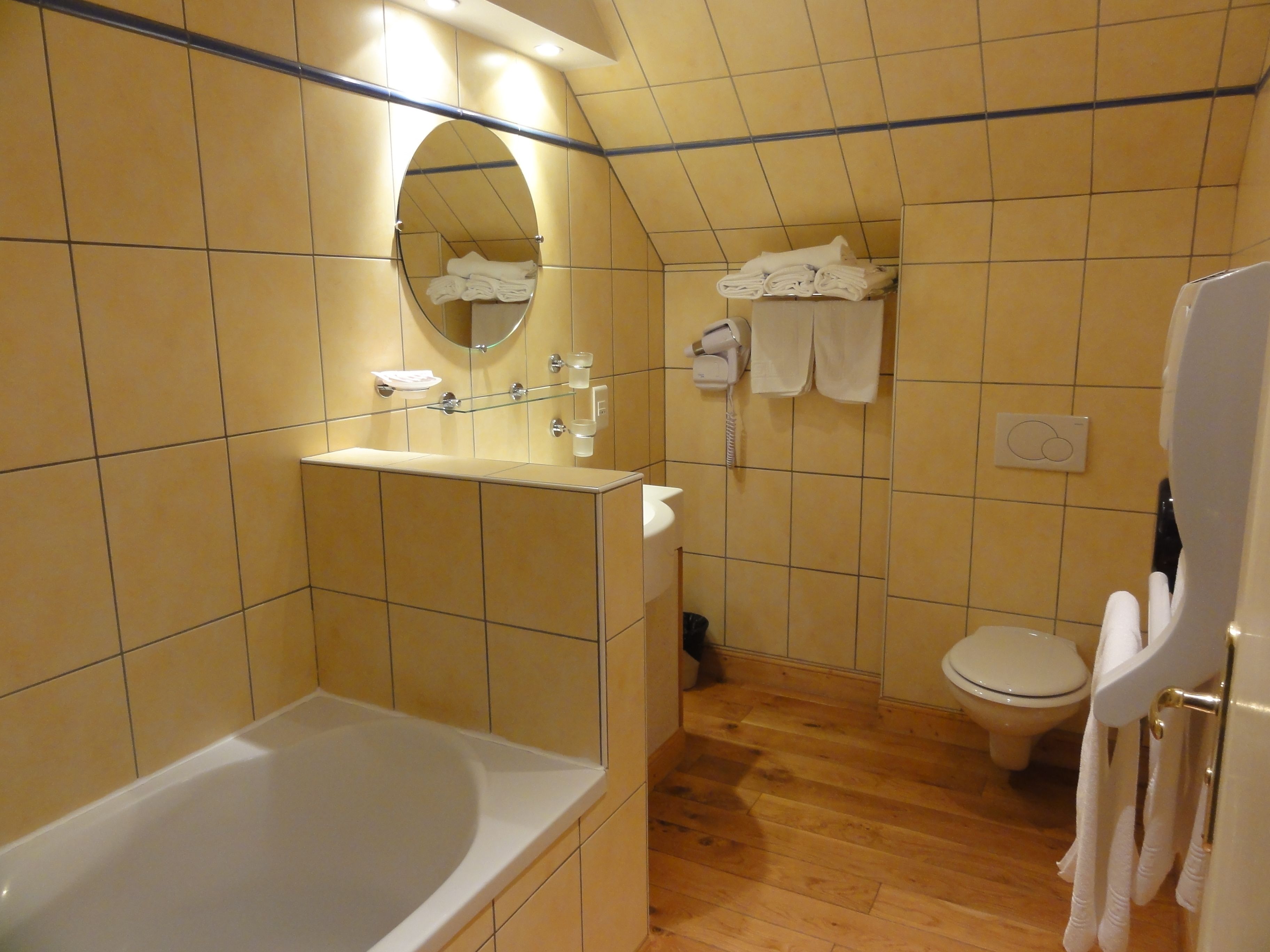 A bathroom with a bathtub, a toilet, and a towel rack.