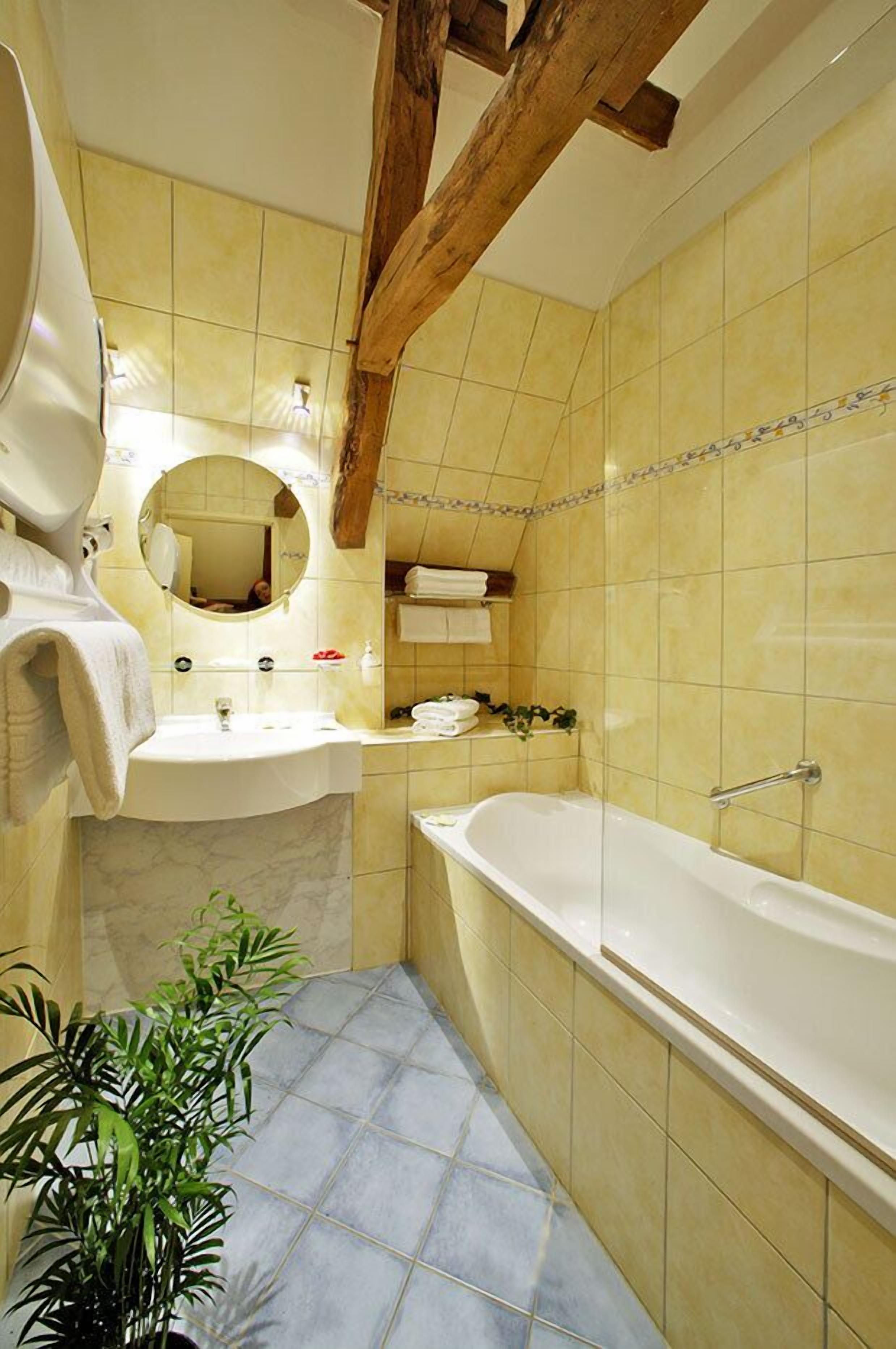 Une salle de bain avec un lavabo, un miroir et une baignoire.