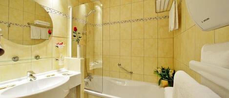 A bathroom with a sink, mirror, shower, and bathtub.