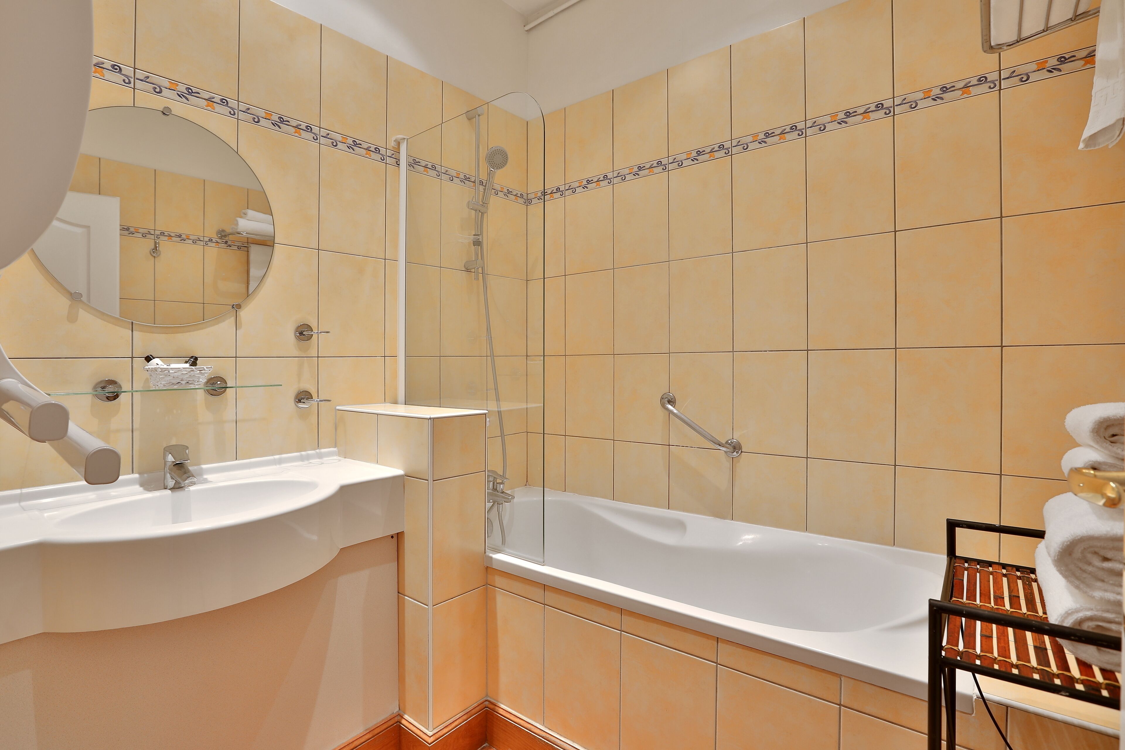A bathroom with a bathtub, two sinks, a mirror, and a towel rack.