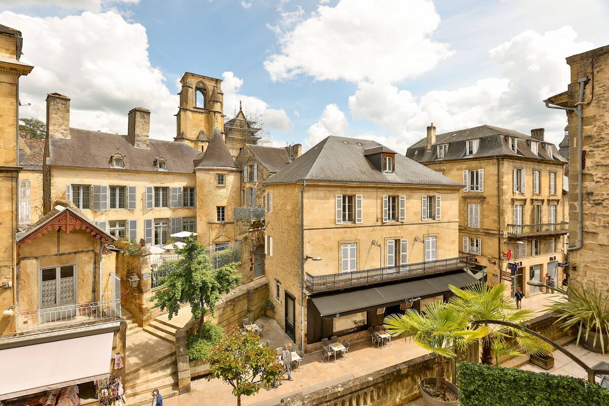 Une ville européenne chargée d’histoire, avec ses bâtiments en pierre, son clocher d’église et un café doté d’une terrasse.