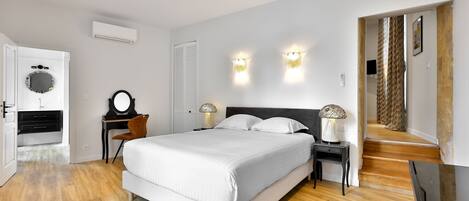Un dormitorio con cama, mesitas de noche y un escritorio.