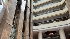 A multi-level atrium with marble columns, a checkered floor, and seating areas. - City Seasons Suites (Dubai)