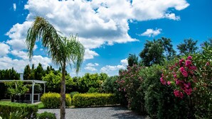 A garden with a pergola, gravel path, and various shrubs and flowers. - Villa Dimokratia (Platanias)
