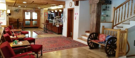 A dining area with wooden furniture and a red carpet.