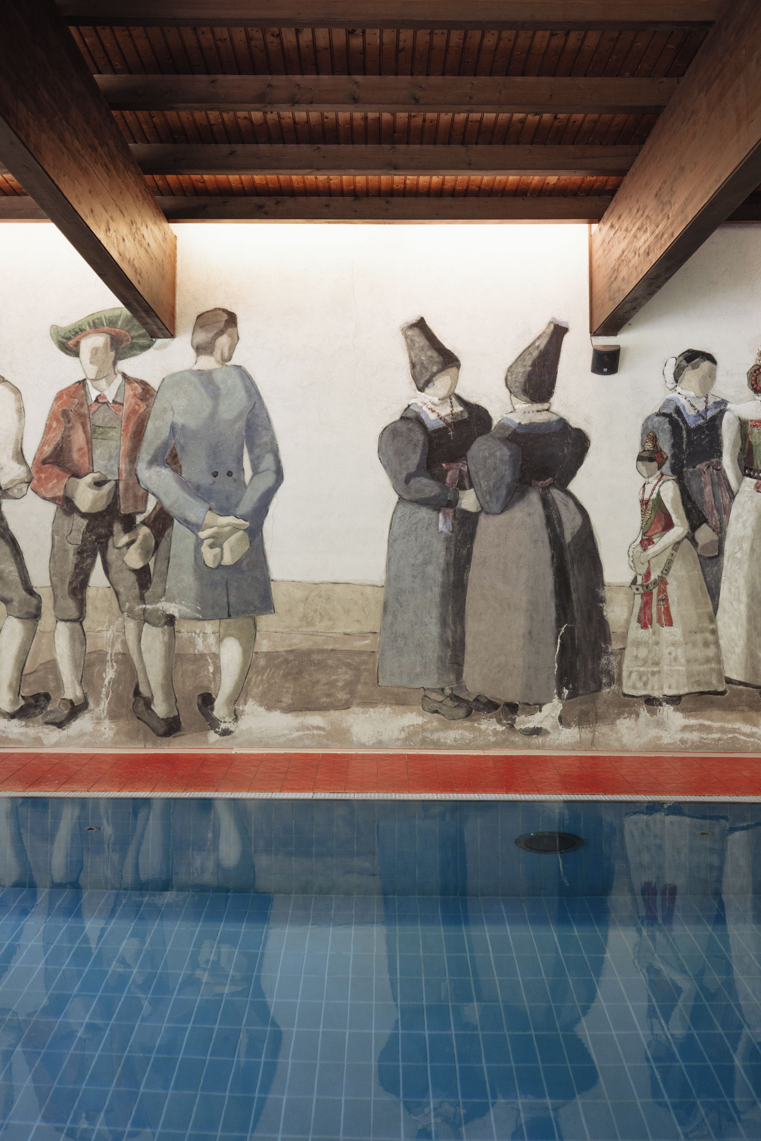 A mural depicting people by a pool with a wooden ceiling and tiled floor.