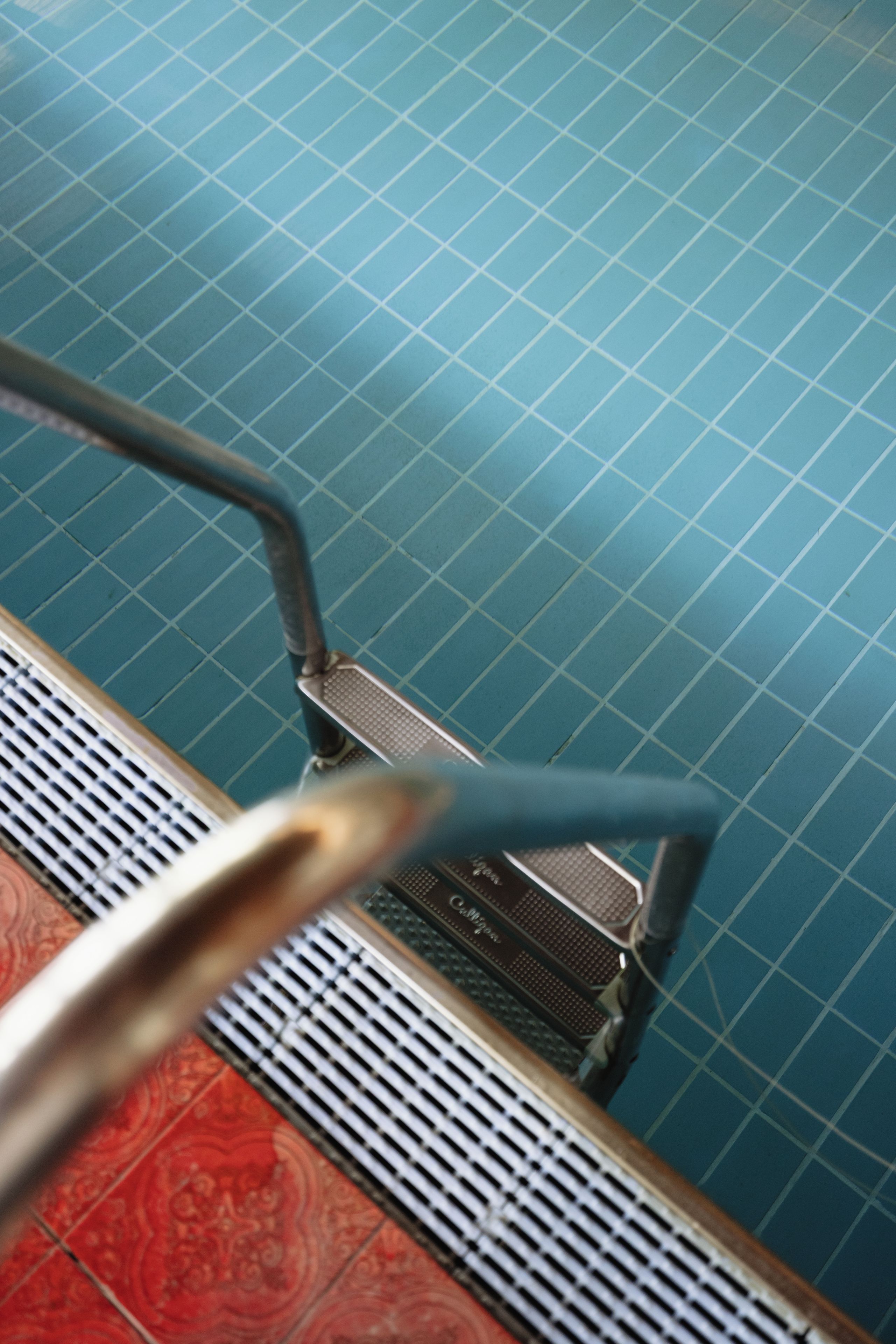 A staircase with a metal handrail and a patterned floor.