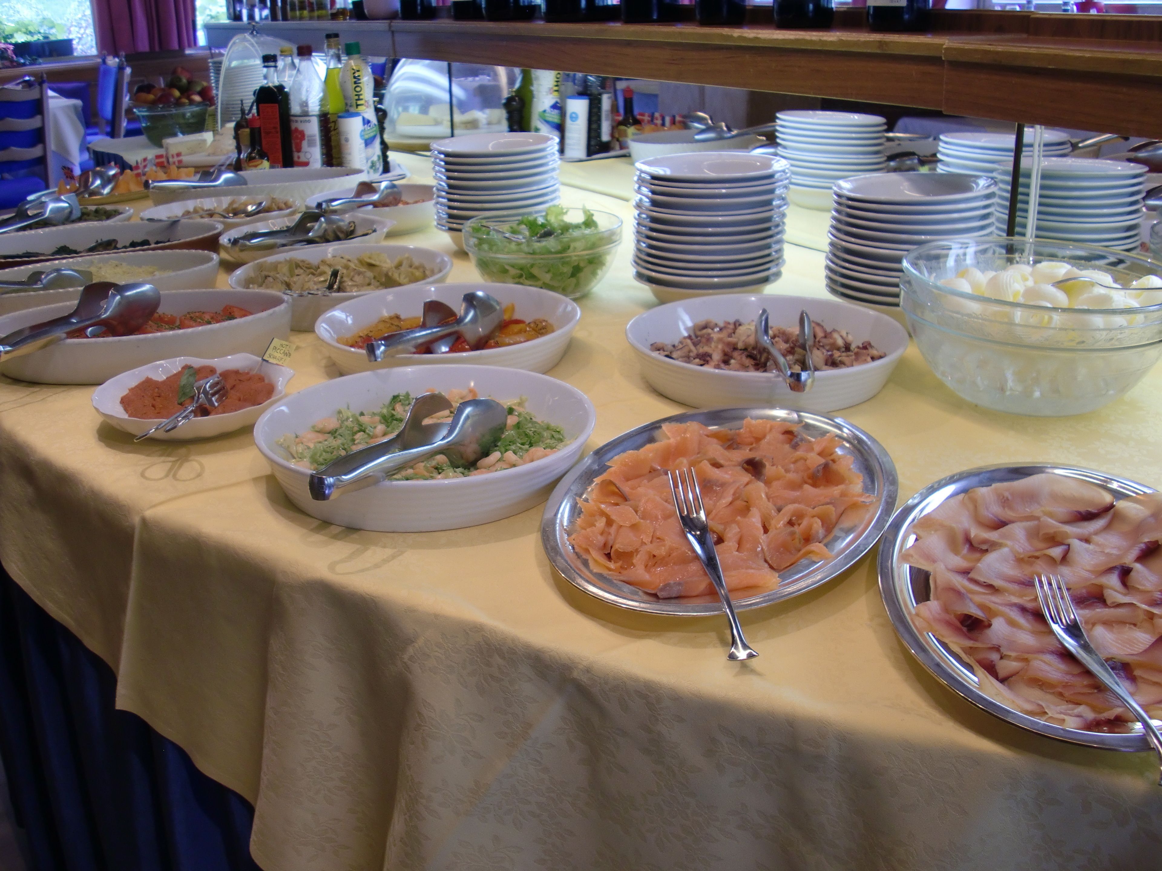 A buffet table with various dishes and utensils.