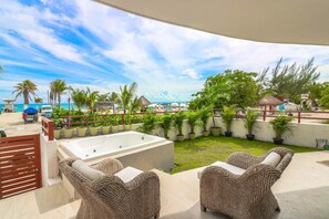 A pool area with a hot tub, wicker chairs, and potted plants. - PDC001 2 Bedroom Apartment By Senstay (Playa del Carmen)