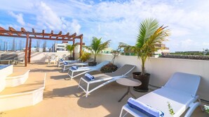 A rooftop terrace with lounge chairs, a pergola, and potted plants. - PDC003 2 Bedroom Apartment By Senstay (Playa del Carmen)