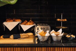 A bakery display with various breads and pastries.