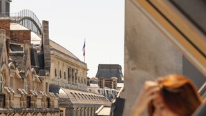 Une vue depuis une fenêtre d’un bâtiment doté de fenêtres en arc de cercle et d’un drapeau.