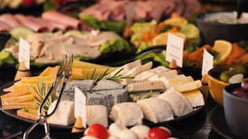 A buffet with various food items including cheeses, meats, and vegetables.