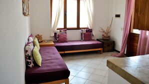 A room with two beds, a window with curtains, a small table, and a potted plant. - Sea View Apartments Boa Vista (Boa Vista)