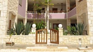 A two-story building with stone walls and a wooden gate. - Sea View Apartments Boa Vista (Boa Vista)